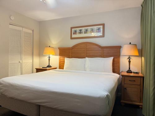 a bedroom with a large white bed with two lamps at Lifetime of Vacations in Orlando