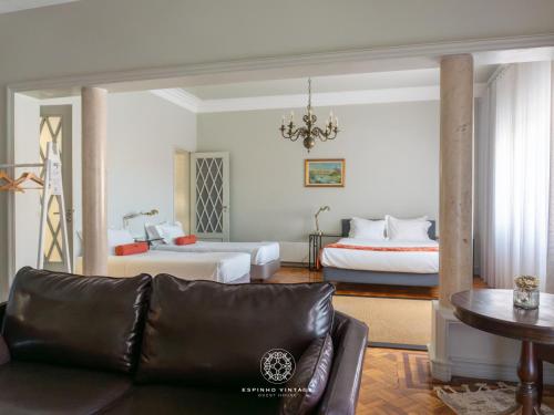 a living room with a couch and two beds at Espinho Vintage - Alojamento de Charme in Espinho