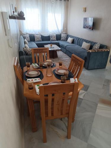 a living room with a table and chairs and a couch at Dar hicham in Hajreien