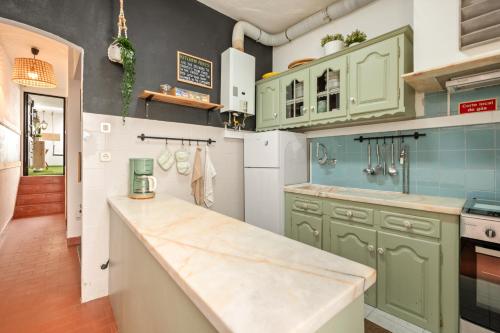 a kitchen with green cabinets and a counter top at Balili Surf House in Baleal