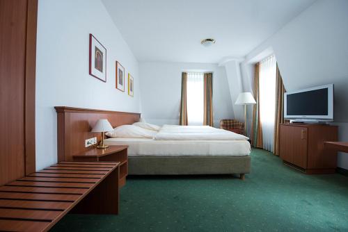 Un pat sau paturi într-o cameră la Hotel Münnich