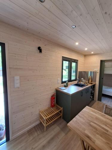 eine Küche mit Herd und Spüle in einem Zimmer in der Unterkunft Tiny House in Weismes