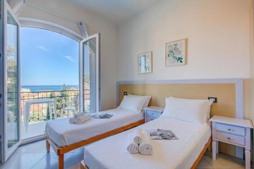two beds in a room with a view of the ocean at Seaview Pool Retreat - Il Poggio in Marina di Andora