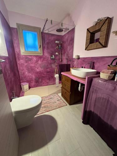 a purple bathroom with a toilet and a sink at House Hermosa Barrabisa in Barrabisa