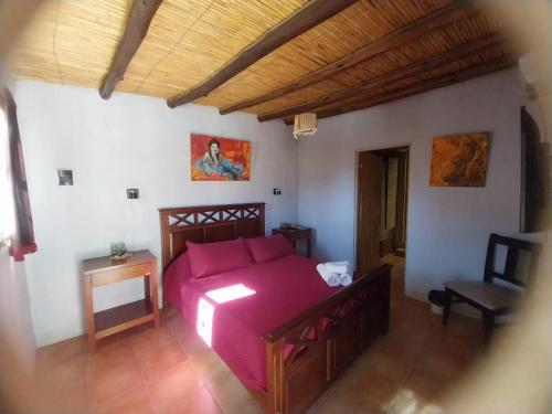 a bedroom with a bed and a chair in a room at Karallantay in Tilcara