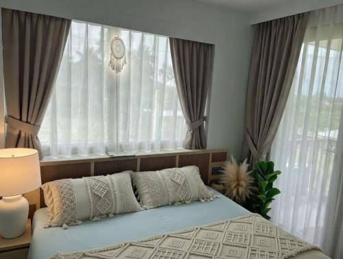 a bedroom with a bed in front of a window at กิตติมา อพาร์ทเม้น in Nathon Bay