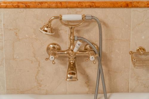 a gold bath tub faucet in a bathroom at Palazzo Benassi Penthouse nel cuore di Asolo in Asolo