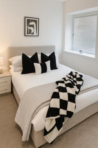 a bedroom with a large bed with black and white pillows at Copper Suite - 2Bed Elegance - Parking in Liverpool