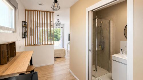 a bathroom with a shower and a sink and a table at Beau Regard in Tournus