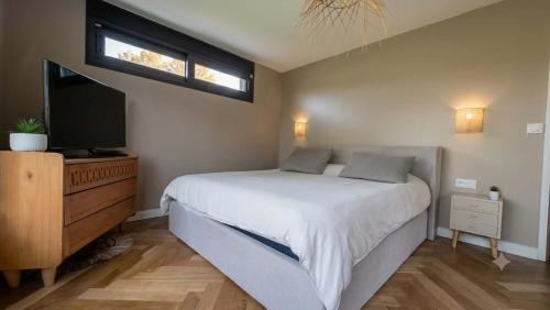a bedroom with a bed and a flat screen tv at Le Bosquet-Villa Prestige, Parking privé, Jardin, Wifi in Lys-lès-Lannoy