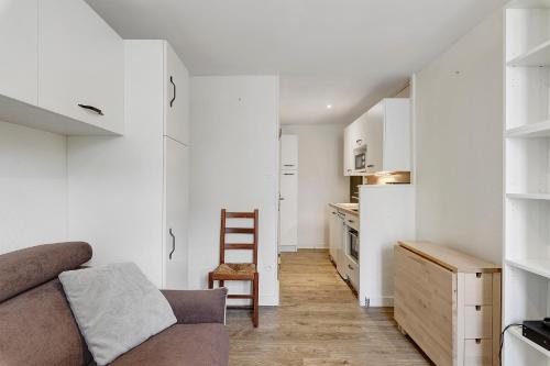 a living room with a couch and a kitchen at Petit cocon cosy en hyper centre in Villard-de-Lans