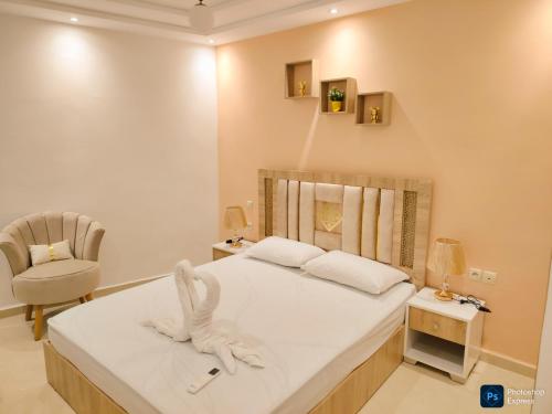 a bedroom with a bed with a towel animal on it at Fantastique Appartement avec piscine sur la plage de Achakar de Tanger - proche du Cap Spartel & la Grotte d'Hercule de TANGER in Tangier