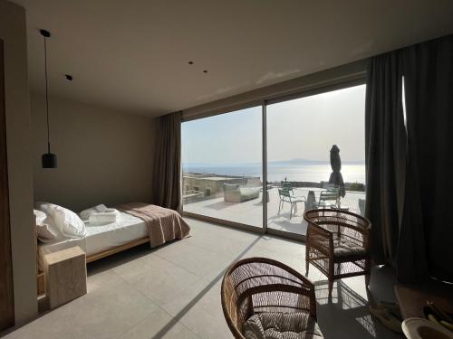 a bedroom with a bed and a view of the ocean at Alos Suites in Verga Kalamata