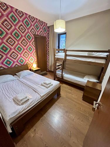 a bedroom with two bunk beds and a colorful wall at Hill House in Kazbegi
