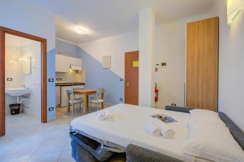 a room with a bed and a kitchen with a table at Seaview Pool Retreat - Il Poggio in Marina di Andora