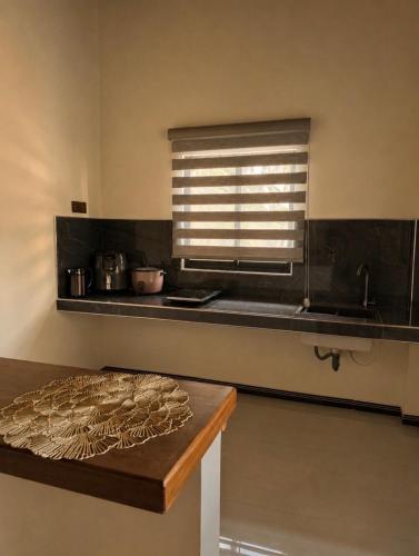 a kitchen with a counter with a window and a table at SIORA Retreat in Dambulla