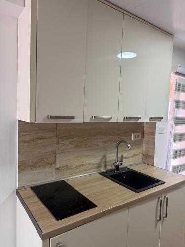 a kitchen with white cabinets and a sink at Apartments Boss in Budva