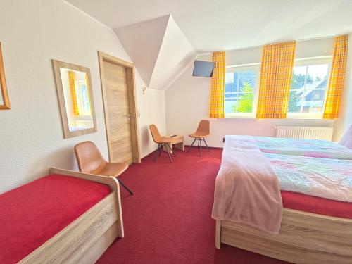 a bedroom with a bed and a table and chairs at Hotel zum Kreuzberg in Winterberg