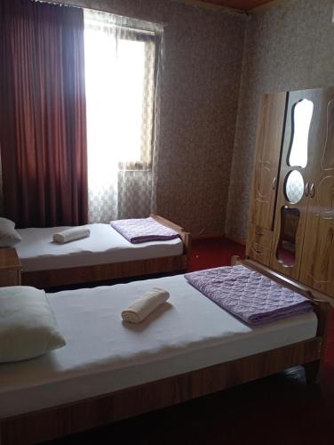 two beds in a room with a window at Guest house TASO in K'veda Gordi