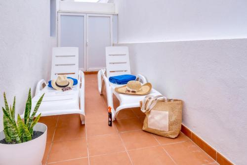 a room with two chairs with hats and a plant at Casa Suso y Casa Margarita- Orzola Coastal Retreat by LVH in Órzola