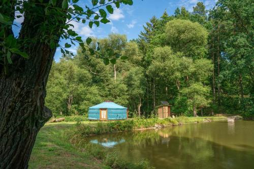 a blue tent sitting next to a lake at Jurta na Jitrech in Tábor