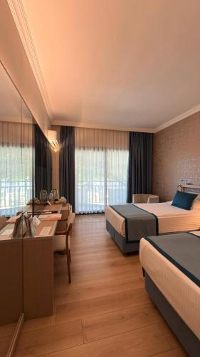 a hotel room with two beds and a couch at Pam Thermal Hotel Clinic & Spa in Pamukkale