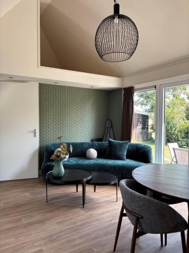 a living room with a blue couch and a table at Lodge Wieringen in Hippolytushoef
