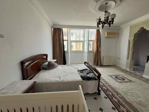a bedroom with two beds and a large window at villa zgolli in Korba