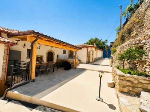 a patio of a house with a stone wall at Ana & Angelo Stone House Vuno Himarë in Vuno