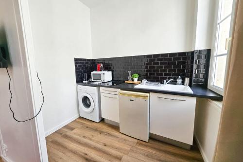 a small kitchen with a sink and a dishwasher at "Les Arches 2" City Center Studio in Saintes