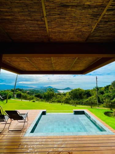 a view of a swimming pool from the deck of a house at Praia do Rosa - Reserva Pilger in Praia do Rosa