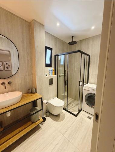 a bathroom with a toilet and a sink and a washing machine at Villa Sea House in Eilat
