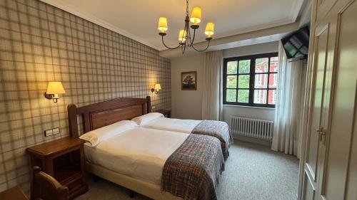 a bedroom with a large bed and a window at Hotel Restaurante De Torres in Felechosa