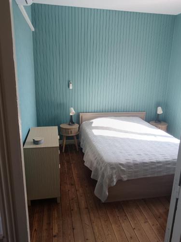 a bedroom with a bed and two tables with lamps at le bégare 