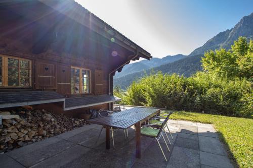 a wooden house with a table and a bench at Les Jumelles in Rougemont