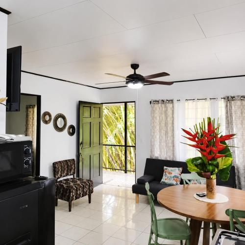 a living room with a table and a ceiling fan at Casa Emma Quepos in Quepos