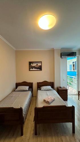 a bedroom with two beds and a light on the ceiling at National Lux in Ureki