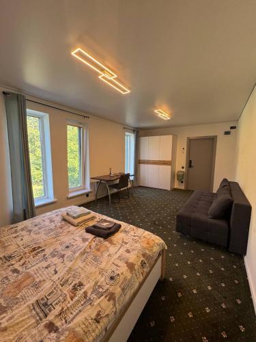 a bedroom with a bed and a couch and a table at Хрю-хрю in Brovary