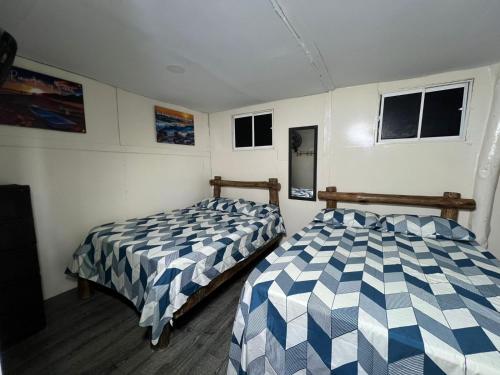 a bedroom with two beds and two windows at Venido del mar beach in Cartagena de Indias