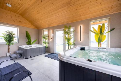 a large bathroom with a large tub and a bathtub at Mazurski domek in Mrągowo