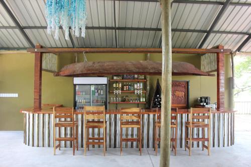 a bar with wooden stools in a room at Caprivi Mutoya Lodge and Campsite in Katima Mulilo