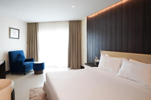 a hotel room with a bed and a blue chair at Royal Twins Palace Hotel in Pattaya
