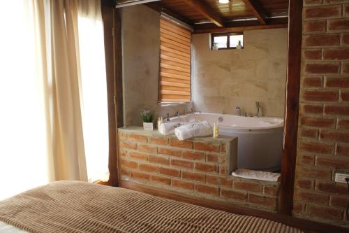 a bathroom with a brick wall and a bath tub at Mount House Lodge in Guano