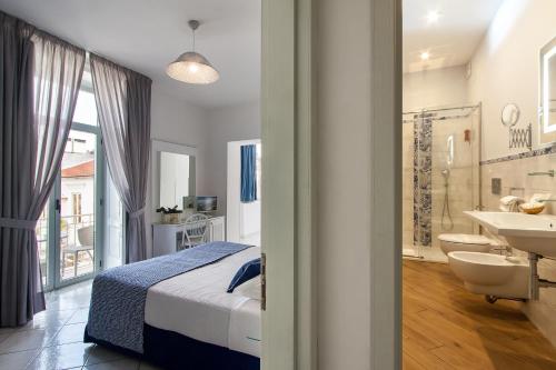 sypialnia z łóżkiem oraz łazienka z umywalką w obiekcie Palazzo Starace w Sorrento