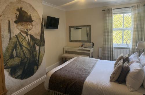 a bedroom with a painting of a man in a suit and hat at The Blue Bell Inn in Weaverthorpe