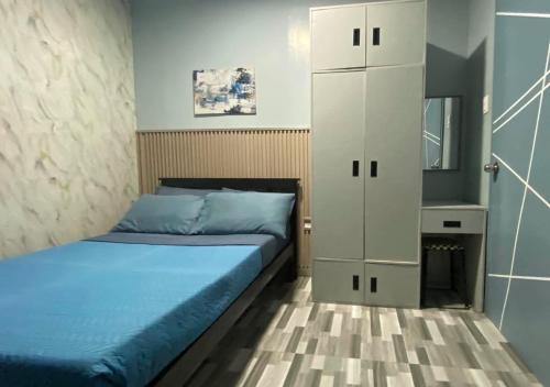 a bedroom with a bed and a white cabinet at Amplayo Apartelle 2-BR Unit in Cagayan de Oro