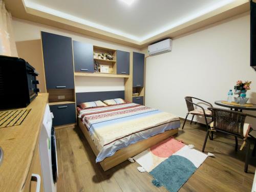 a small bedroom with a bed and a table at Apartmani N&D in Kumanovo