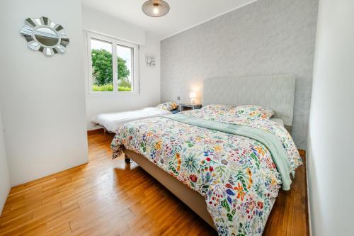 a bedroom with a large bed and a window at La Maison de Rolie in Plévin