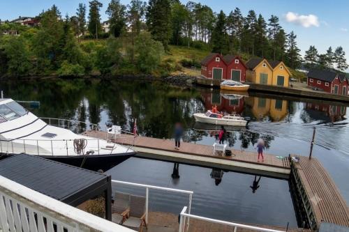 a boat docked at a marina with people on a dock at Boat Included, Waterfront Villa, Near Bergen in Lindås