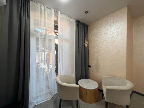 a room with two chairs and a table and a window at U Dominicana in Kamianets-Podilskyi
